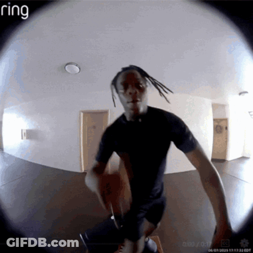 A Ring Camera Shows A Man In A Black Shirt Standing In A Hallway GIF