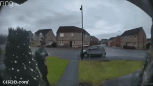 A Ring Doorbell Shows A Man Walking Down A Residential Street GIF