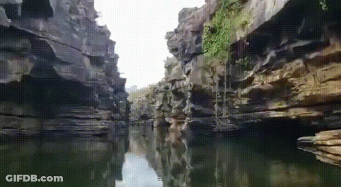 A River Runs Through A Narrow Canyon Surrounded By Cliffs GIF