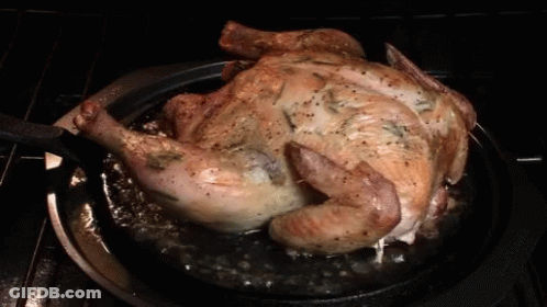 A Roasted Chicken Is Being Cooked In A Pan On A Stove GIF