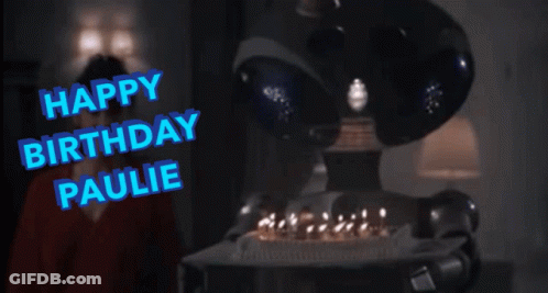 A Robot Holding A Birthday Cake With The Words Happy Birthday Paulie Written In Blue GIF