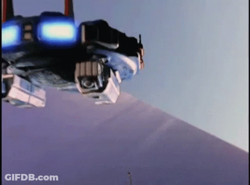 A Robot Is Sitting On Top Of A Snow Covered Mountain . GIF