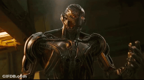 A Robot Is Standing In A Dark Room With A Yellow Light Behind It GIF