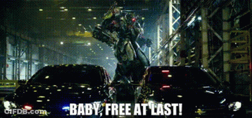 A Robot Is Standing Next To A Car With The Words Baby Free At Last Written On It GIF