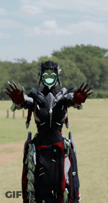 A Robot With A Green Face Is Standing In A Field With Trees In The Background GIF