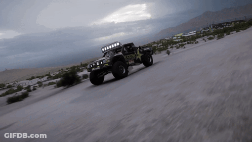 A Rockstar Truck Is Driving Down A Sandy Road GIF