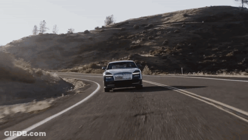 A Rolls Royce Car Is Driving Down A Winding Road GIF