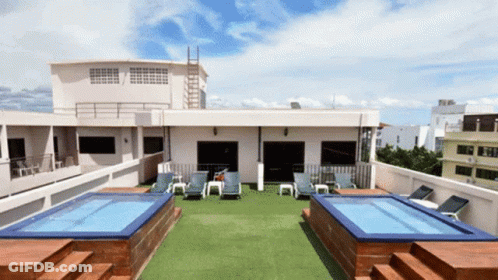 A Rooftop With A Swimming Pool And Chairs GIF