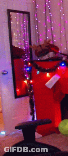 A Room With Christmas Lights Hanging On The Wall GIF
