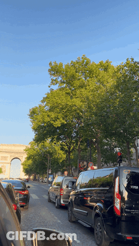 A Row Of Cars Are Lined Up On A Busy Street GIF