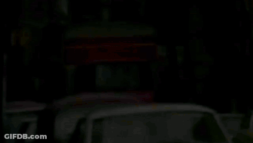 A Row Of Cars Are Parked On The Side Of The Road GIF