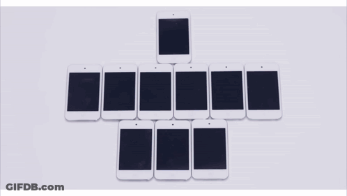 A Row Of Cell Phones Are Lined Up In A Row On A Table GIF