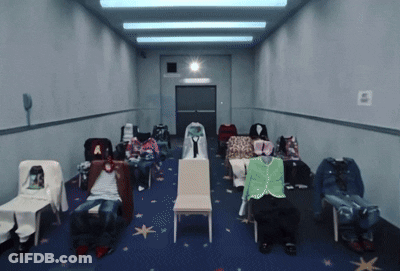A Row Of Chairs Are Lined Up In A Hallway With A Sign On The Wall That Says E GIF