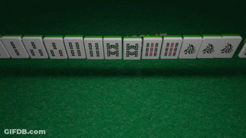 A Row Of Chinese Mahjong Tiles On A Green Mat GIF