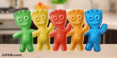 A Row Of Colorful Gummy Bears Are Sitting On A Counter GIF
