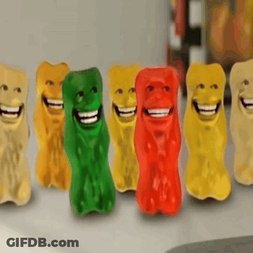 A Row Of Colorful Gummy Bears With Smiley Faces On Them GIF