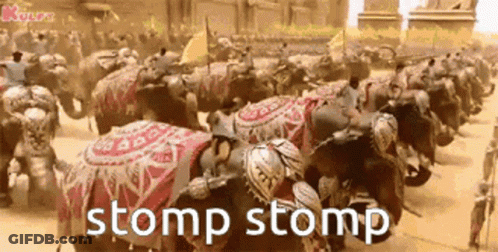 A Row Of Elephants Are Lined Up In A Parade With The Words Stomp Stomp Written Below Them . GIF