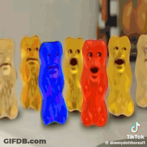 A Row Of Gummy Bears With Faces Are Lined Up In A Row GIF
