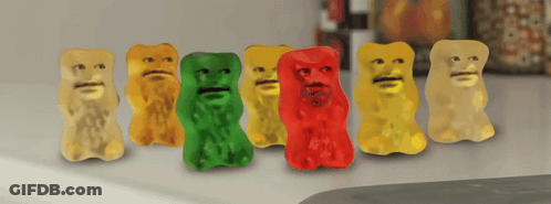 A Row Of Gummy Bears With Faces Are Lined Up On A Counter GIF