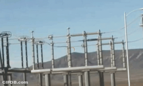 A Row Of Power Lines With Mountains In The Background GIF