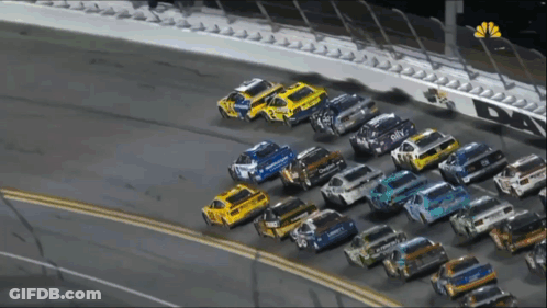 A Row Of Race Cars Are Lined Up On A Race Track With A Nbc Logo In The Corner GIF