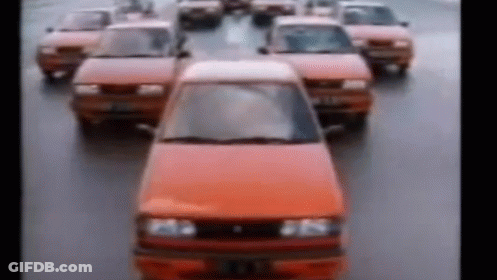 A Row Of Red Cars Are Driving Down A Street In A Blurry Photo . GIF