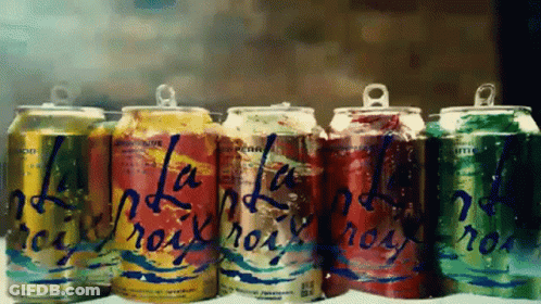 A Row Of Soda Cans With One That Says ' La ' On It GIF