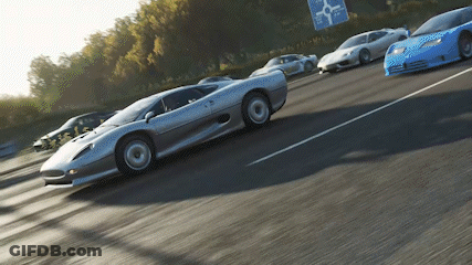 A Row Of Sports Cars Are Driving Down A Highway With A Sign That Says ' A Few Miles Ahead ' GIF