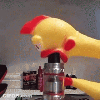 A Rubber Chicken Is Holding A Bottle Of Ketchup In Its Mouth . GIF