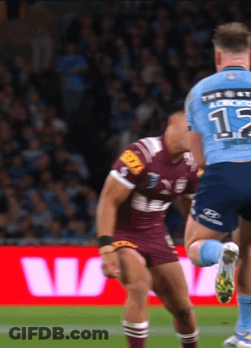 A Rugby Player Wearing A Number 12 Jersey Is Being Tackled By Another Player GIF