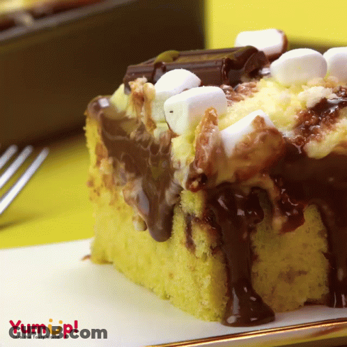 A S'mores Cake With Chocolate Sauce And Marshmallows On Top Of It GIF