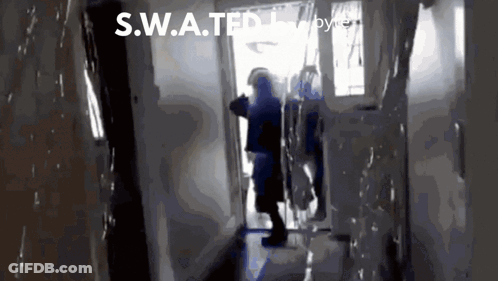 A S.w.a.t.f.i. Officer Stands In A Hallway GIF