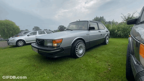 A Saab Car Is Parked In A Grassy Area GIF