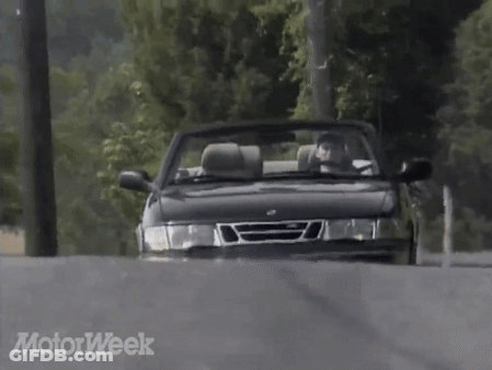 A Saab Convertible Is Driving Down A Road With Motorweek Written In The Corner GIF