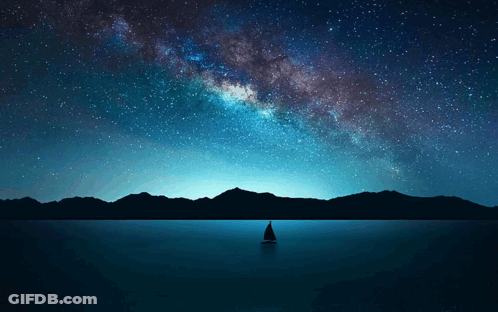 A Sailboat In The Middle Of A Lake With Mountains In The Background GIF