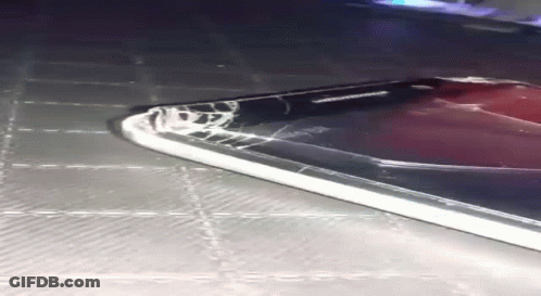 A Samsung Phone With A Cracked Screen Is Laying On A Table GIF