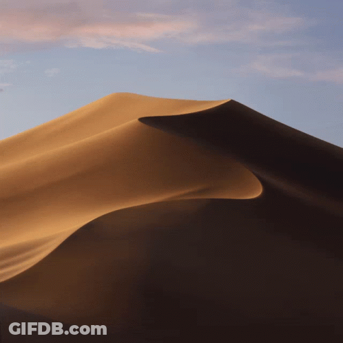 A Sand Dune In The Desert With A Blue Sky Behind It GIF