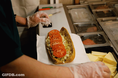 A Sandwich With Tomatoes Lettuce And Cheese Is Being Prepared GIF
