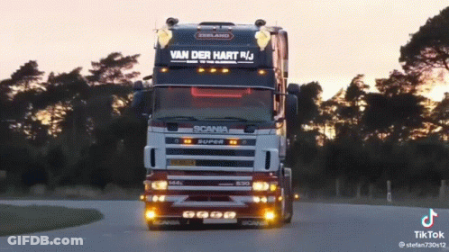 A Scania Truck Is Driving Down The Road GIF