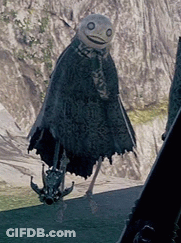 A Scarecrow Is Standing In Front Of A Mountain And Holding A Sword GIF