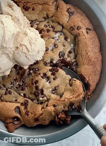 A Scoop Of Ice Cream Is Being Poured On Top Of A Cookie GIF