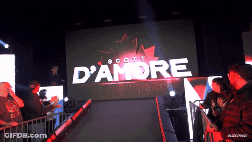 A Scott D' Amore Sign Is Displayed On A Large Screen GIF