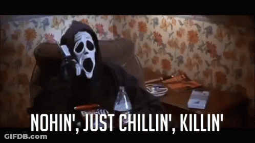A Scream Masked Person Is Sitting On A Couch Talking On A Cell Phone .. GIF