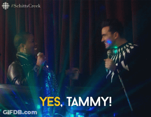 A Screenshot From Schitts Creek Shows A Man And A Woman On Stage GIF