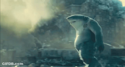A Shark Is Standing In Front Of A Building In A City . GIF