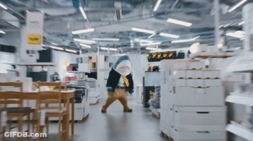 A Shark Mascot Is Walking Through A Store With A Sign That Says 39.99 GIF