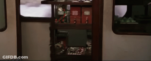 A Shelf In A Train Car Has A Few Books On It Including One That Says ' Harry Potter ' On It GIF