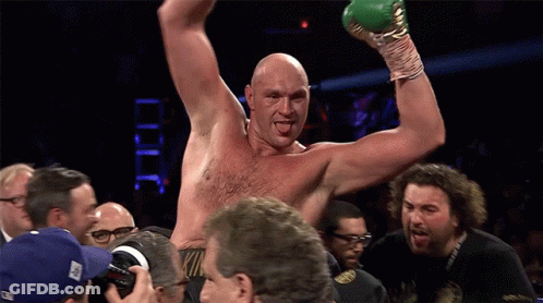 A Shirtless Boxer Is Being Congratulated By A Group Of People GIF