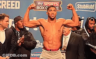 A Shirtless Boxer Is Flexing His Muscles In Front Of A Sign That Says Sky Sports Box Office GIF