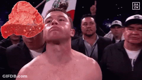 A Shirtless Boxer Stands In Front Of A Mexican Flag And A Large Piece Of Meat GIF